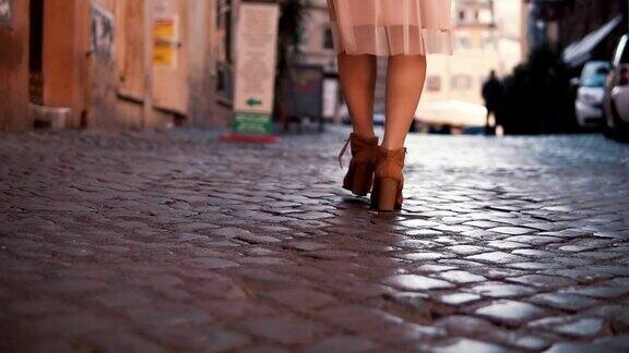 走在鹅卵石铺就的路上的女人女孩探索新的城市穿着鞋和裙子特写镜头