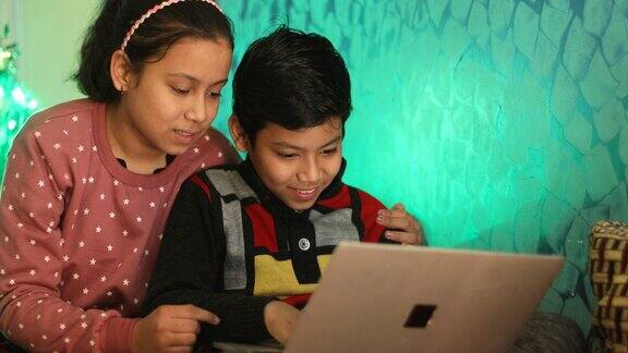 弟弟和妹妹玩在家里使用笔记本电脑