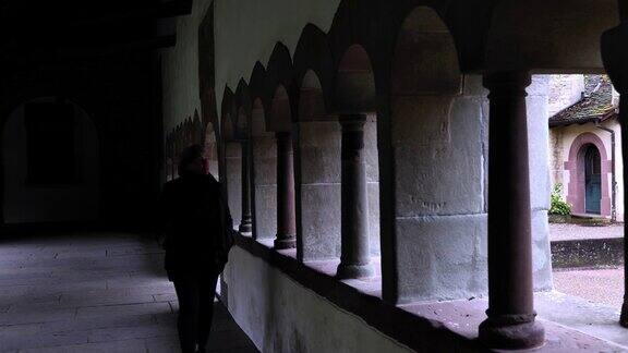 一个女人走在沙夫豪森有柱子和灯光的教堂天井里