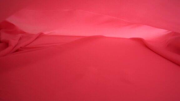 一个背景纹理柔软的红色织物纺织材料反向移动