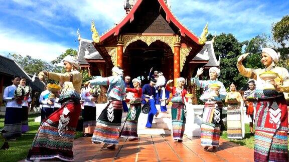 年轻男女穿着传统泰国服装跳舞和撒兰花花在寺庙-4K