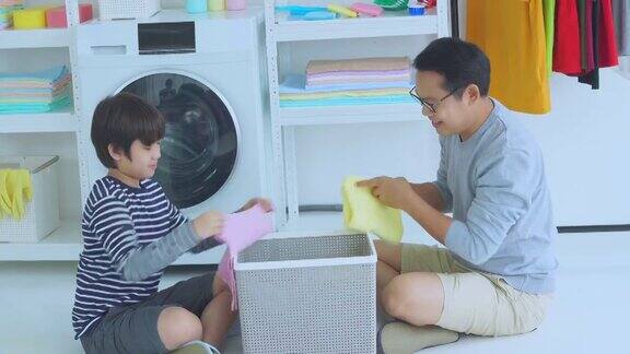 一个男孩和他的父亲在一起做家务以防止病毒的传播他们一起愉快地打扫了家