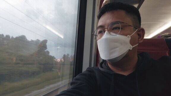 亚洲中国中年男子透过窗户看火车旅行在晚上反思