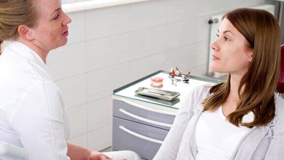 女牙医在诊所里与女病人交谈工作中的女专业医生牙科检查