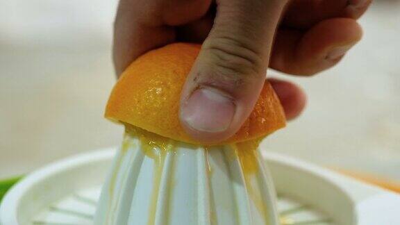 男子用手挤鲜橙汁准备健康早餐维生素