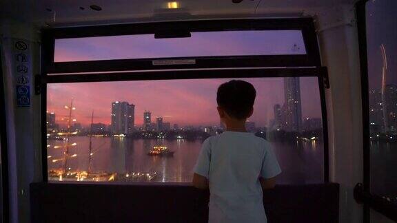 亚洲小孩晚上在曼谷的摩天轮上假期和梦想