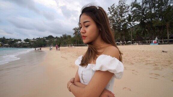 一个可爱的亚洲女孩在阴天的海滩上