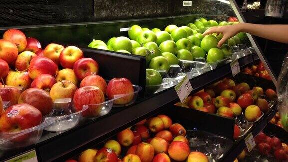 在杂货店挑选新鲜绿苹果的女人