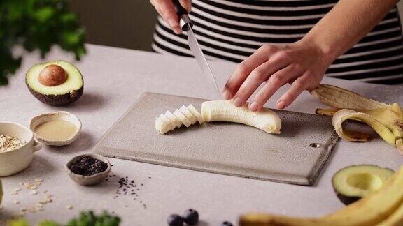 在厨房切香蕉做水果冰沙碗的女人