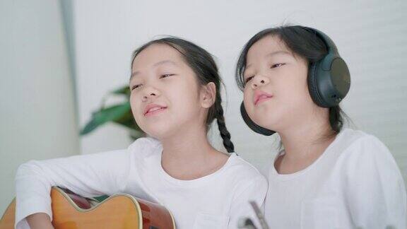 音乐教室里热情歌唱和弹吉他的两个小女孩
