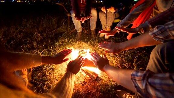 快乐的人们坐在篝火旁晚上晚上时间