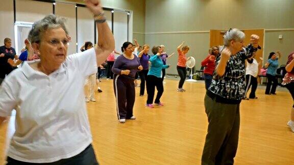 各种各样的老年妇女在健身课上跳舞