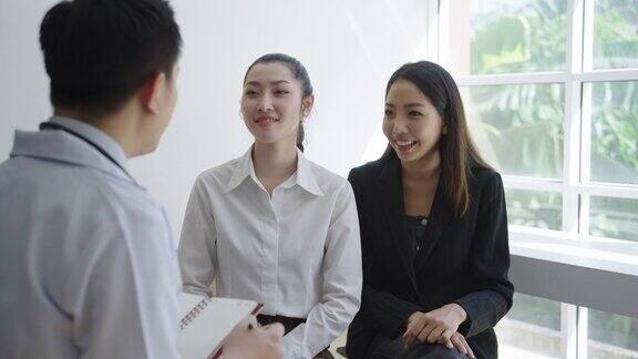 一个亚洲男性整形外科医生的肖像与一个女性病人在诊所咨询医学检查医学和保健