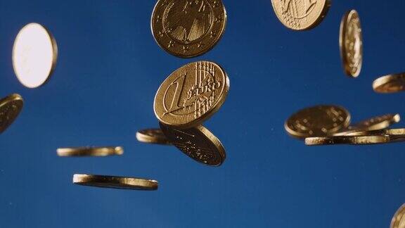 蓝色背景下用金箔包裹的欧元巧克力硬币在空中飞舞