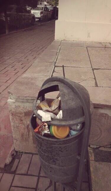 城市里装满的垃圾桶在镜头中移动贫民区的城市小巷
