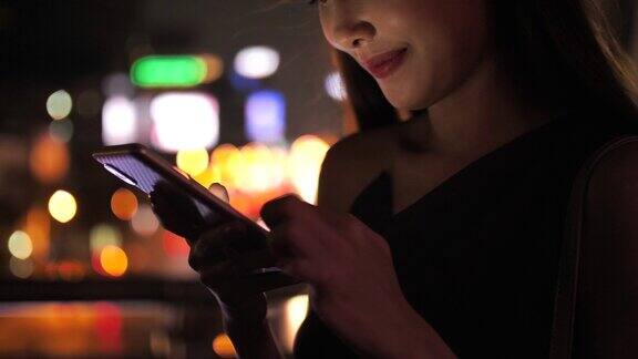 亚洲妇女在城市街道上使用手机