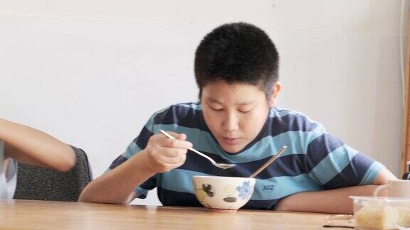 快乐的亚洲孩子在家里一起吃速食面汤生活理念