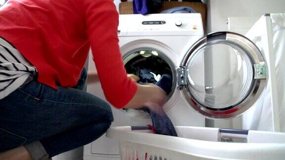 把衣服放进洗衣机的女人