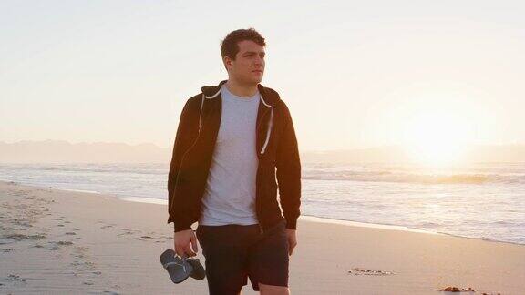 太阳升起时年轻人在海滩上散步