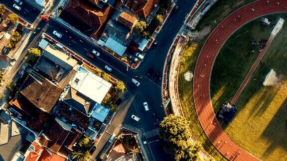 Timelapse俯视图体育场慢跑轨道旁边繁忙的十字路口在印度尼西亚