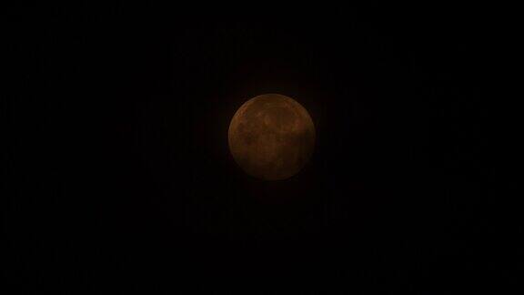 4k延时拍摄黄色超级月亮在天空中移动直到落入黑暗的云层