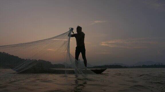 日落时分渔民在湖边用小船撒网渔民的生活方式泰国华富里以、亚洲