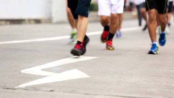 马拉松赛跑人们脚踩在城市的道路上