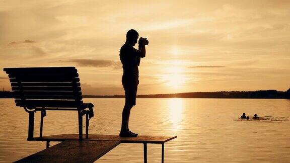 摄影师在日落时拍摄风景