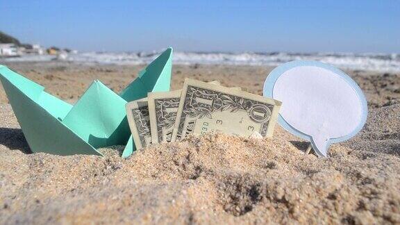 阳光明媚的夏日小绿纸船、三张一元纸币和空白的话语泡在海边的沙滩上概念货币金融商务旅游旅游梦想休息假期假期