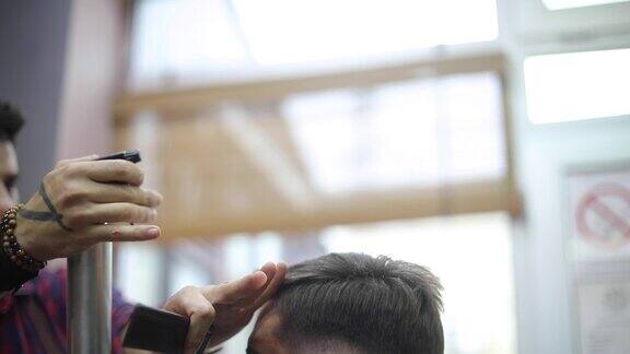 男理发师在理发店为男士理发