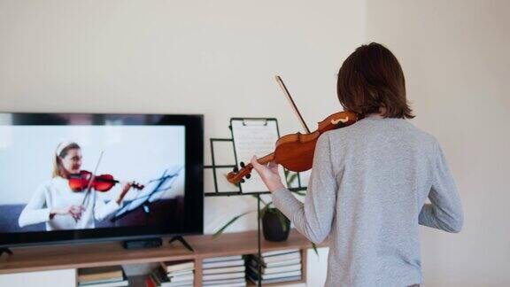 男孩在网上和老师学习小提琴