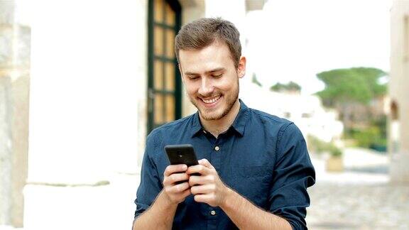 在街上用手机发短信的快乐男人