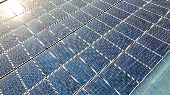蓝色光伏太阳能电池板表面鸟瞰图安装在建筑屋顶产生清洁的生态电力生产可再生能源概念