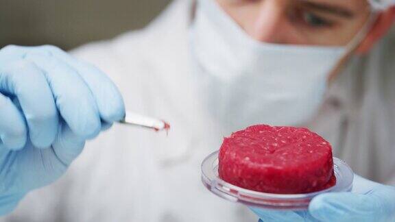 一位年轻的科学家正在实验室检查和分析人工肉样品