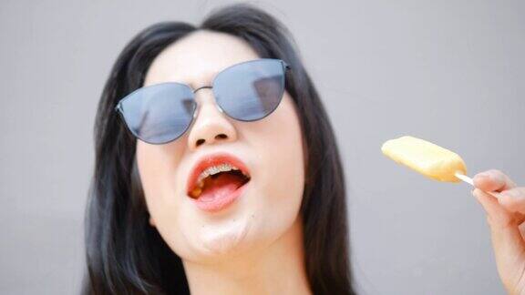快乐的亚洲游客一边吃冰淇淋一边在城市里散步旅游概念