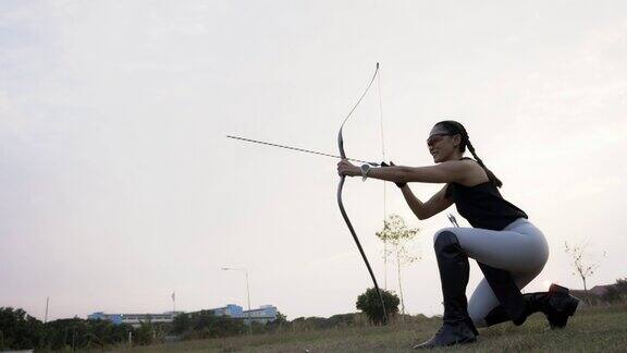 特写迷人的亚洲女性练习射箭在靶场