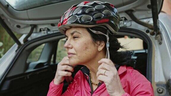 50岁早期女性自行车运动员在锻炼前戴上头盔