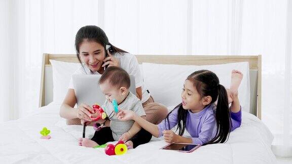 亚洲母亲与婴儿的女儿女孩和婴儿使用笔记本电脑的家庭生活方式