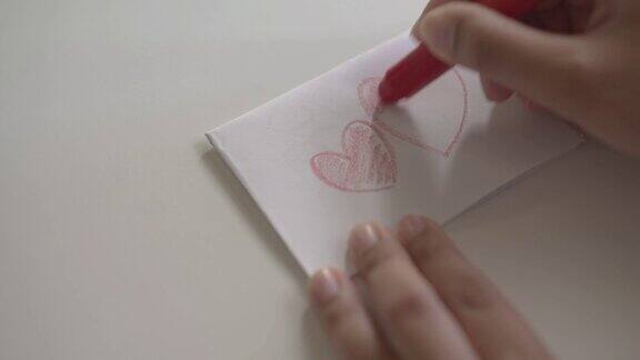 一位妇女用蜡笔在白纸上画了一颗红心