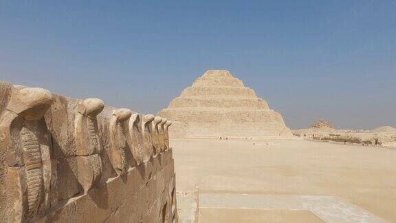 蛇形石雕与远处萨卡拉阶梯金字塔的景色