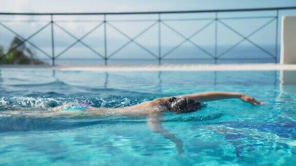 度假时享受无边泳池的女人穿游泳谷歌