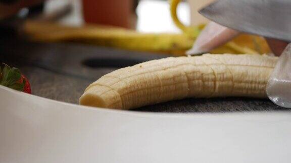 特写厨师手戴手套用刀切香蕉做成甜点或果泥