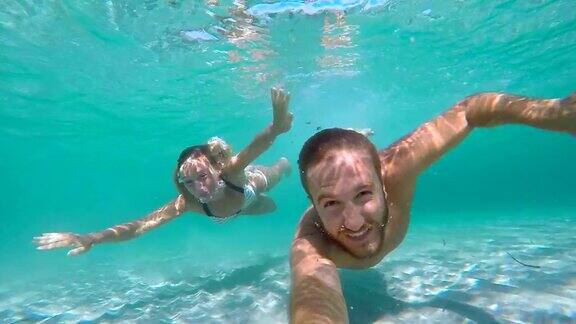 一对年轻夫妇用动作相机在水下自拍