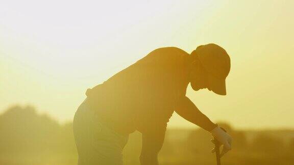日出时在球道上开球的男高尔夫球手