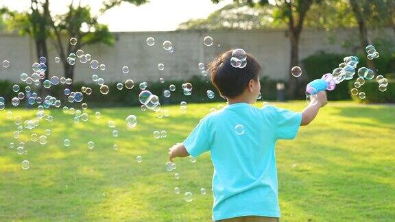 亚洲小孩在公园玩泡泡幸福和夏日