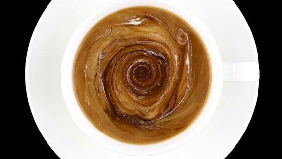 一杯咖啡俯视图热奶油被倒入咖啡中变成美丽的液体图案