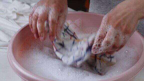 用泡沫和洗衣粉在盆中清洗湿的格纹毛巾用洗衣粉清洗脏衣服洗衣概念手洗去污剂的广告