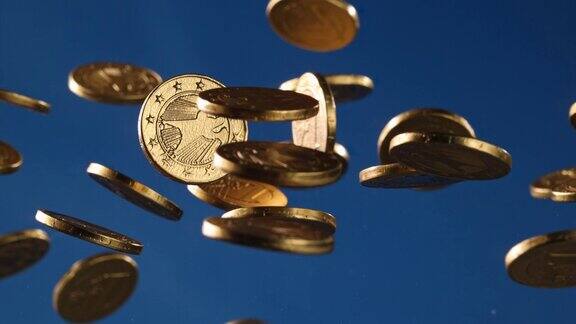 蓝色背景下用金箔包裹的欧元巧克力硬币在空中飞舞