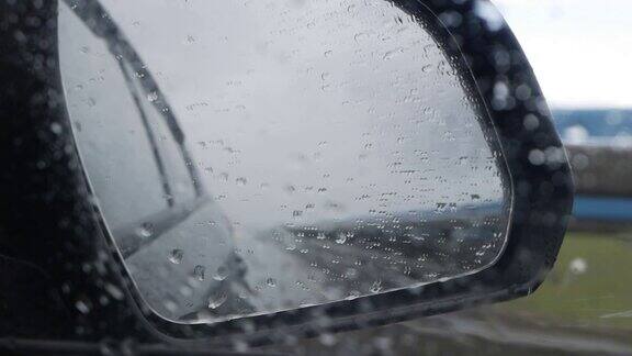 当汽车在雨中行驶在高速公路上时从后视镜看出去