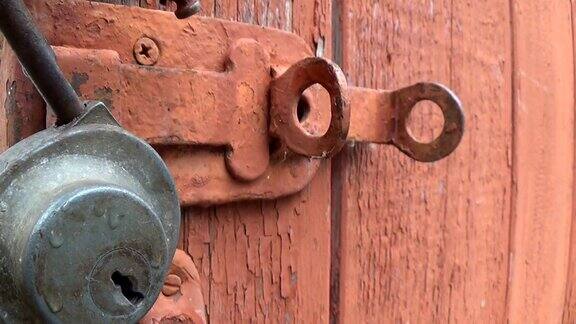 旧木门上的摇摆锁带有剥落和刮漆的纹理背景